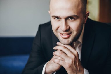 Siyah takım elbiseli şık damat sabahleyin hazırlanıyor.