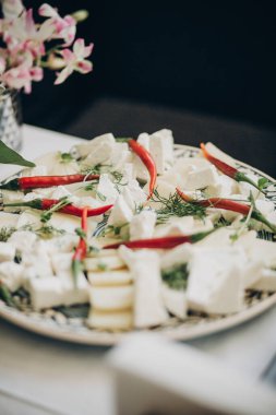 Keçi peyniri, kırmızı biber ve yeşil aperatifler evlilikte masada.