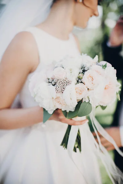 Moderní svatební kytice v rukou nevěsty. Nádherná nevěsta v bílém g — Stock fotografie