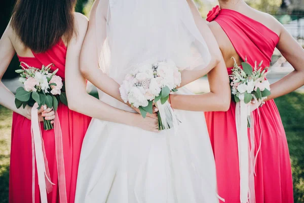 Hermosa novia posando con damas de honor en vestidos de color rosa, sosteniendo —  Fotos de Stock