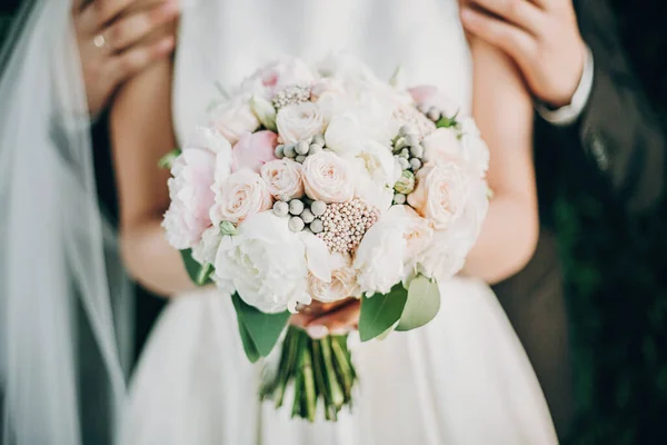 Bouquet de casamento moderno em mãos de noiva. Elegante noivo gentilmente abraço — Fotografia de Stock