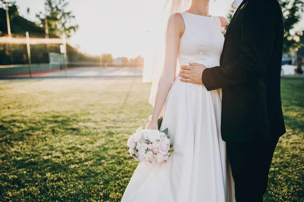 Preciosos novios abrazándose suavemente a la luz del atardecer. Beautif. — Foto de Stock