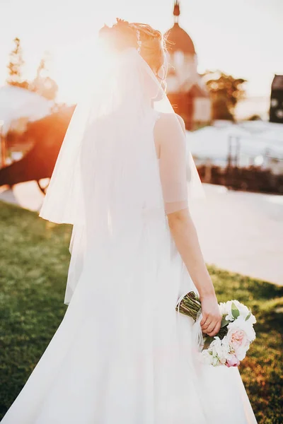 Ramo de boda moderno en manos de novia al atardecer. Hermosa novia —  Fotos de Stock