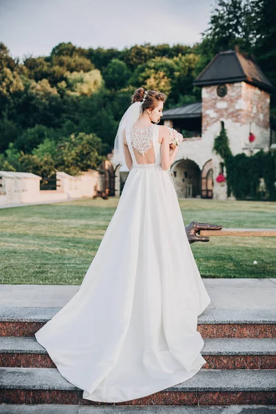 Wunderschöne Braut in atemberaubendem Kleid beim Spaziergang im Abendpark. Braut in — Stockfoto