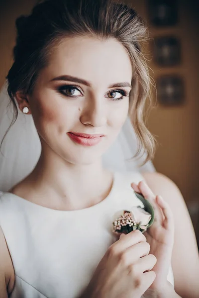 Krásná smyslná nevěsta drží stylové boutonniere, pózování v blízkosti — Stock fotografie