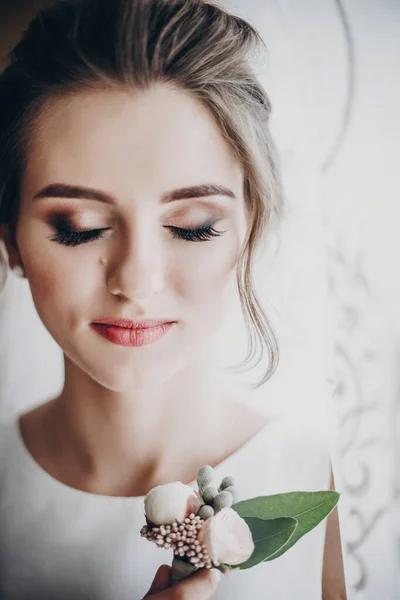 Schöne sinnliche Braut hält stylische boutonniere, posiert in der Nähe — Stockfoto