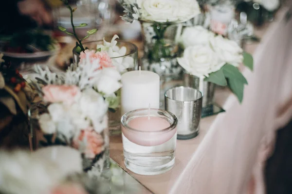 Vela, flores brancas em vaso de vidro moderno em peça central rosa . — Fotografia de Stock
