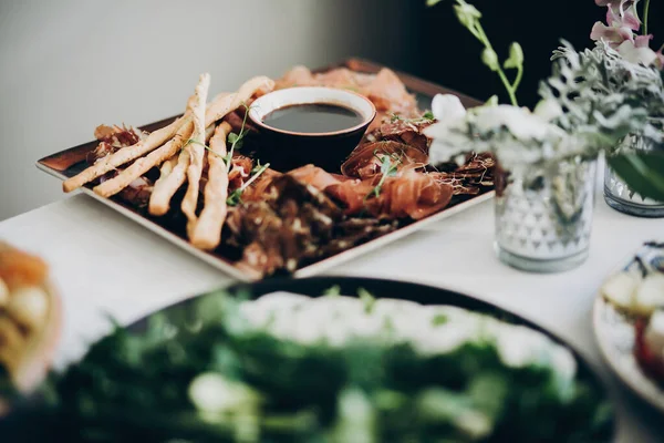 Gerookt vlees, saus, prosciutto, salade hapjes op tafel bij weddi — Stockfoto