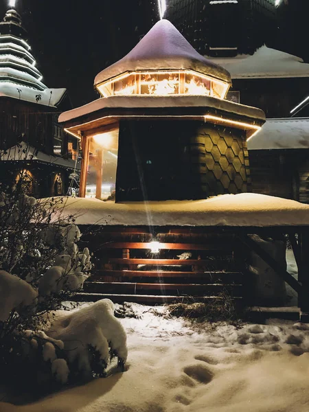 Holzkirche mit Lichtern und beleuchteten Kreuzen auf den Gipfeln in sno — Stockfoto