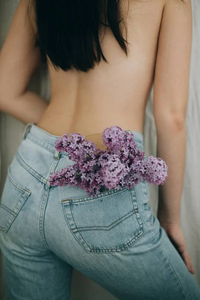 Vrouw Poserend Met Lila Bloemen Spijkerbroekzak Rustieke Achtergrond Bloeiende Lila — Stockfoto