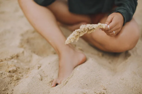 Hipsterka Trzymająca Zioło Siedząca Plaży Przycięty Widok Opalone Nogi Stylowa — Zdjęcie stockowe