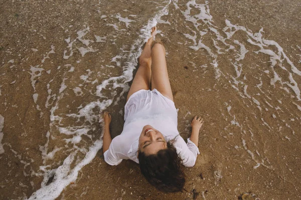 Gelukkige Jonge Vrouw Wit Shirt Liggend Het Strand Spetterende Golven — Stockfoto