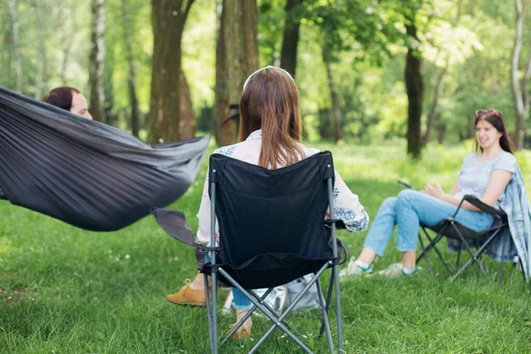 Social distancing. Small group of people enjoying conversation at picnic with social distance in summer park. Leisure activity together in new normal, gatherings following safety protocols