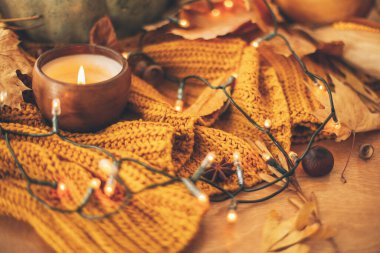 Merhaba sonbahar. Sıcak, kırsal, karamsar görüntü. Balkabağı, sonbahar yaprakları, mum, sıcak ışıklar ve meşe palamudu, ceviz, sarı örülmüş yaban mersini ve kır ağacı. Seçici odak