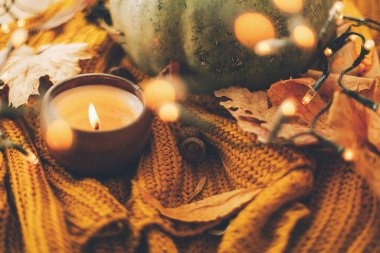 Merhaba sonbahar. Sıcak, kırsal, karamsar görüntü. Balkabağı, sonbahar yaprakları, mum, sıcak ışıklar ve meşe palamudu, ceviz, sarı örülmüş yaban mersini ve kır ağacı. Seçici odak