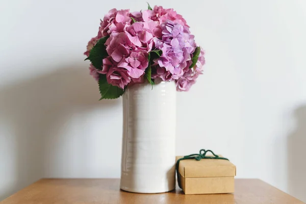 Hortensia Boeket Vaas Geschenkdoos Achtergrond Van Witte Muur Met Kopieerruimte — Stockfoto