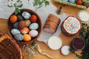 Paskalya yemeği düzdü. Paskalya yumurtaları doğal boyanmış, paskalya ekmeği, jambon, pancar, tereyağı, yeşil dallar ve hasır sepet ve mumla kaplı ahşap masa üzerinde çiçekler. Geleneksel Paskalya Yemeği