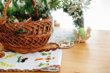 Geleneksel Paskalya sepeti, kilisede kutsanmak için yiyecek ve ahşap masa üzerindeki sepet için geleneksel Ukrayna nakış havlusu, mum ve yeşil boxwood dalları ve çiçekler.