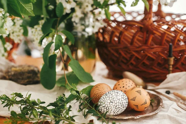 复活节快乐 零浪费 天然的复活节彩蛋 以柳条篮 白色春花和木制桌子上的绿叶为背景 用蜡涂在老式盘子上 别致的乡村静谧生活 — 图库照片