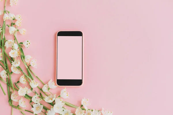 Pinkfarbenes Smartphone Mit Leerem Bildschirm Und Weißen Frühlingsblumen Auf Rosafarbenem — Stockfoto