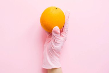 Pembe arka planda turuncuyu tutan pembe eldiven. Karantinada güvenli alışveriş. İnternetten yemek sipariş et ve evde kal. Virüs salgınını önlemek için. Kendine dikkat et..