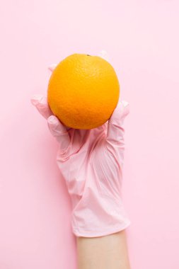 Pembe arka planda turuncuyu tutan pembe eldiven. Karantinada güvenli alışveriş. İnternetten yemek sipariş et ve evde kal. Virüs salgınını önlemek için. Kendine dikkat et..