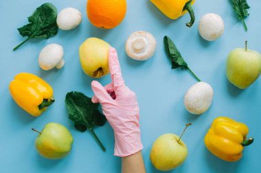 Mavi arka plandaki sebzeli sebzeleri düzleştirerek pembe eldiveni getir. Taze organik yiyecek sipariş et ve karantina sırasında güvenli bir şekilde teslim et. Evde kal. Kendine dikkat et. Önleme