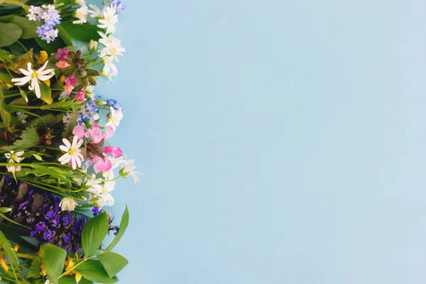 青い紙の背景に野生の花のカラフルな境界線は テキストのためのスペースとフラットレイアウト 春の花を咲かせ 花のグリーティングカードテンプレート 幸せな母の日の概念 こんにちは春 — ストック写真