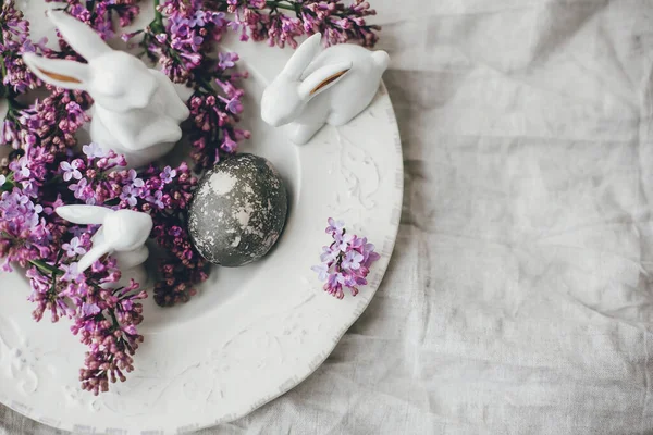 时尚的复活节白兔 古板上有现代的复活节彩蛋 亚麻布上有紫丁香花 天然染色的复活节彩蛋和春花 文字空间 复活节快乐 — 图库照片