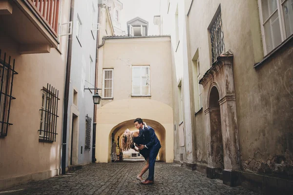古い建築を背景にヨーロッパの街の通りで踊るスタイリッシュなカップル 街中で情熱を持って踊る愛の中でファッショナブルな男と女 ヨーロッパを旅する — ストック写真