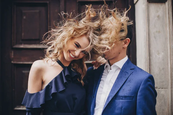 在欧洲城市的大街上 一对时髦的夫妇在嬉笑 时尚的情绪女人挥动着头发 对着恋爱中的男人微笑 浪漫的快乐时刻情人节 — 图库照片