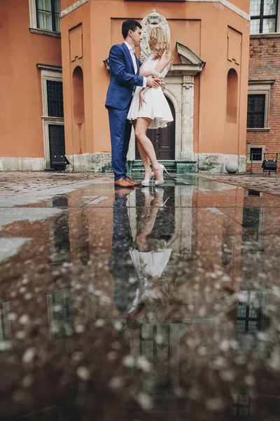 古い建築と水の反射を背景に ヨーロッパの街の通りで踊るスタイリッシュなカップル 恋のダンスでファッショナブルな男と女 ヨーロッパを旅する — ストック写真