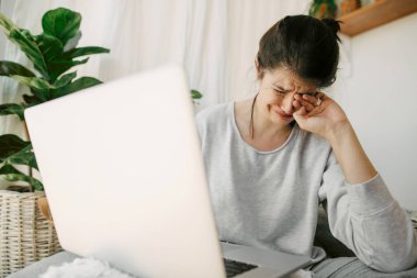 Kötü haberden ağlayan üzgün kız karantina sırasında dizüstü bilgisayarla evde tek başına oturuyor. Genç bir kadın işini ve depresyonunu kaybetmekten endişeleniyor. İşsizlik ve ekonomik kriz. Mali istikrarsızlık