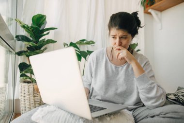 Laptoptan kötü haberler okuyan üzgün kız, karantina sırasında evde tek başına oturuyor. Genç bir kadın işini ve depresyonunu kaybetmekten endişeleniyor. İşsizlik ve ekonomik kriz. Mali istikrarsızlık