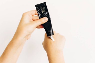 Elleri yıkadıktan sonra siyah tüpten nemlendirici krem sürmek ve virüs salgını sırasında alkol jeli kullanmak. Kuru cilt tedavisi. Lüks cilt bakımı. El kremi. Kuru deriden sakınma