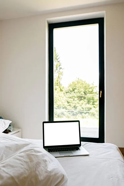 Ноутбук Порожнім Білим Екраном Ліжку Тлі Великого Вікна Сучасній Кімнаті — стокове фото
