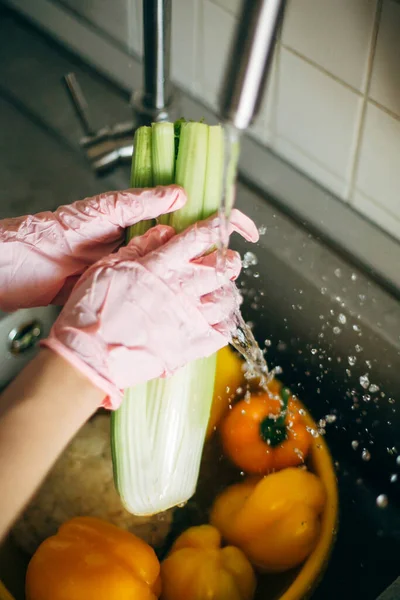 Tangan Sarung Tangan Merah Muda Mencuci Seledri Dalam Percikan Air — Stok Foto