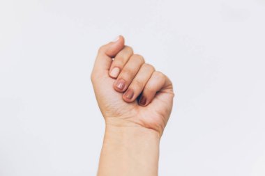Beyaz arka planda kadın yumruğu protestosu. Farklı tırnak renkleri, ten ve ırk çeşitliliği olan bir kadın el kaldırılmış. Kadın hakları kavramı. Irkçılığı bırak