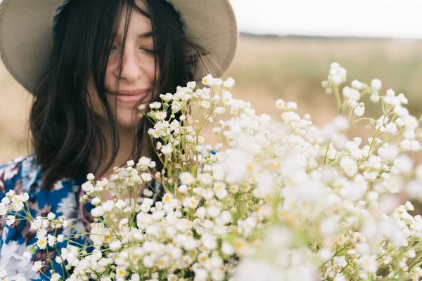 風の強い分野で大きなデイジー花束を持つ美しい女の子の官能的な肖像画 田舎の夏 美しい若いです女性で青ヴィンテージドレスと帽子保持白い野花で牧草地 — ストック写真