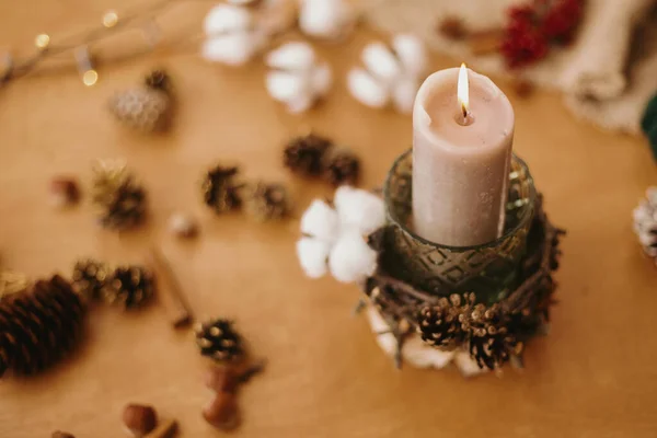 圣诞蜡烛是用树枝 茴香和松果做成的 放在木制桌子上 上面点着节日的彩灯 假日工作坊制作乡村圣诞烛光装饰 — 图库照片