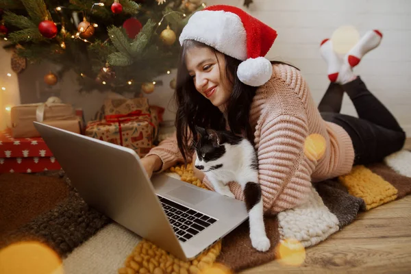 Dizüstü Bilgisayarında Sevimli Bir Kediyle Noel Ağacının Altında Hediyelerle Oturan — Stok fotoğraf