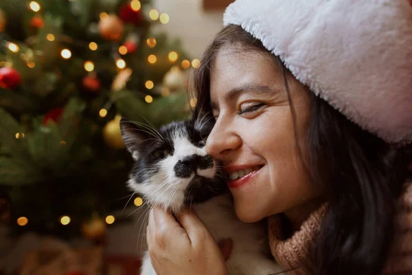 Gelukkig Meisje Santa Hoed Knuffelen Schattig Kat Achtergrond Van Kerstboom — Stockfoto