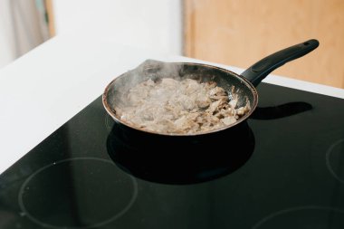 Modern beyaz mutfakta kavrulmuş mantar ve soğan. Evde pizza yapma süreci, malzemeler kapanıyor. Ev yemeği konsepti
