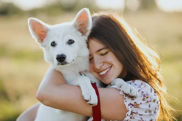 Mujer Abrazando Lindo Cachorro Blanco Cálida Luz Del Atardecer Prado — Foto de Stock