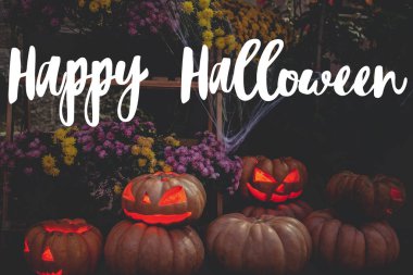 Mutlu Cadılar Bayramı tebrik kartları. El yazısıyla Mutlu Cadılar Bayramı metni, kabak kabaklı, parlak yüzlü ve siyah örümcek ağlı korkunç balkabağı..