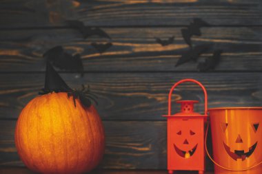 Mutlu Cadılar Bayramı! Örümcek ve cadı şapkalı balkabağı, fener kovası Jack ve arka planda yarasalar. El yapımı tatil süslemeleri, evde cadılar bayramı kutlamaları.