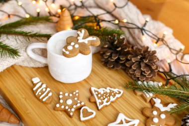 Noel zencefilli geyik kurabiyesi aromalı kahve, rahat örgü süveter, çam kozalakları, köknar dalları ve sıcak ışıklar. Merhaba kış. Mutlu Noeller ve mutlu tatiller!