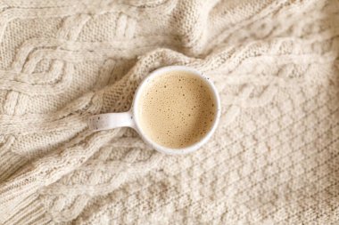 Süslü fincanda sıcak kahve, rahat örülmüş kazak, üst manzara. Atmosferik kış ikizi ya da sıcacık sonbahar yatağı. İyi tatiller.