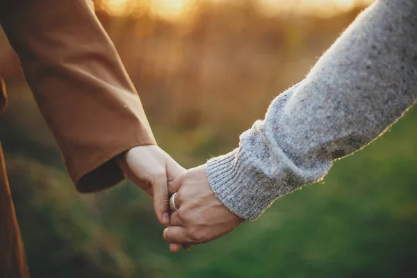 秋の牧草地で暖かい日没の光の中で静かに手を握って官能的なカップル 太陽の下で手を握っている若い男と女のクローズアップ ロマンチックな一緒に瞬間 概念的なイメージ — ストック写真