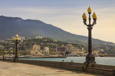 Orta Yalta ve çevredeki dağların eski fener ile dekore edilmiş waterfront, üzerinden görüntüleyin. Crimea.